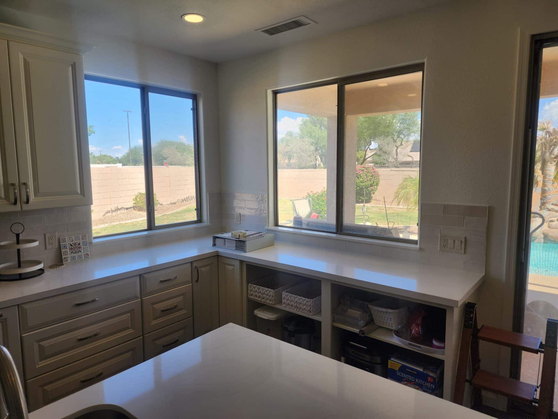 Gilbert kitchen with white quartz countertops, tile backsplash and built-in open shelving